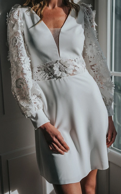 Vestido de novia corto moderno de manga larga con escote en V, apliques y abertura en forma de ojo de cerradura.