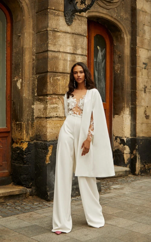 Mono de novia con escote barco y mangas largas efecto ilusión, pantalón y chaqueta.