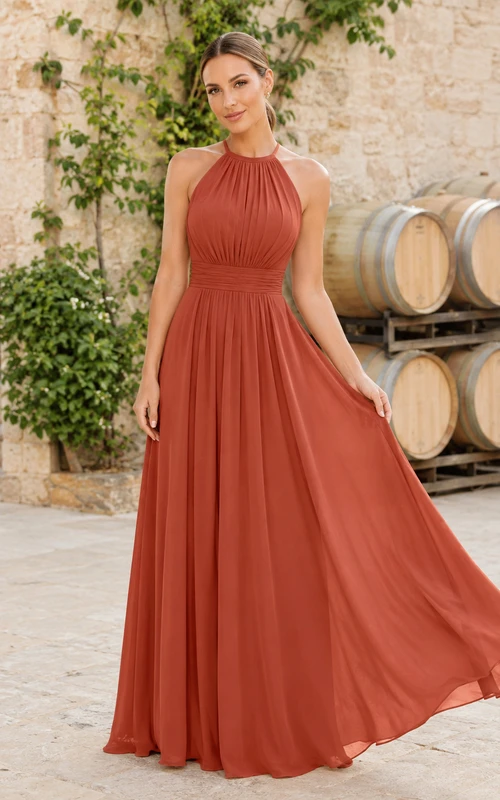 Robe de demoiselle d'honneur longue en mousseline couleur terre cuite, coupe trapèze, col montant, sans manches, plissée, dos nu et col licou.